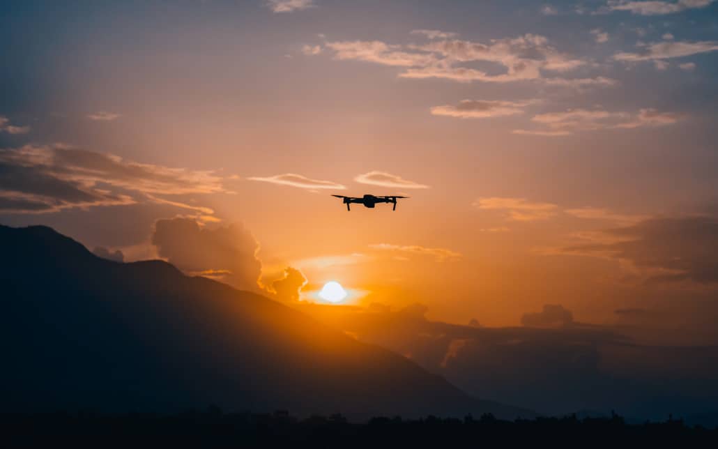 drone volant dans les montagnes face au soleil